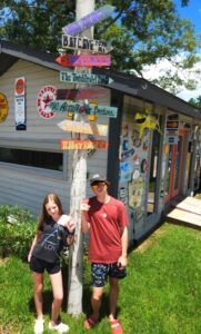 Young boy and girl standing next to sign post with retro signs pointing to fictional locations