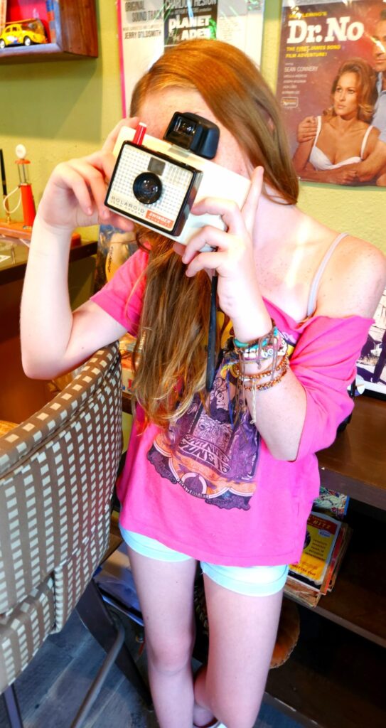 Young girl holding retro Polaroid camera